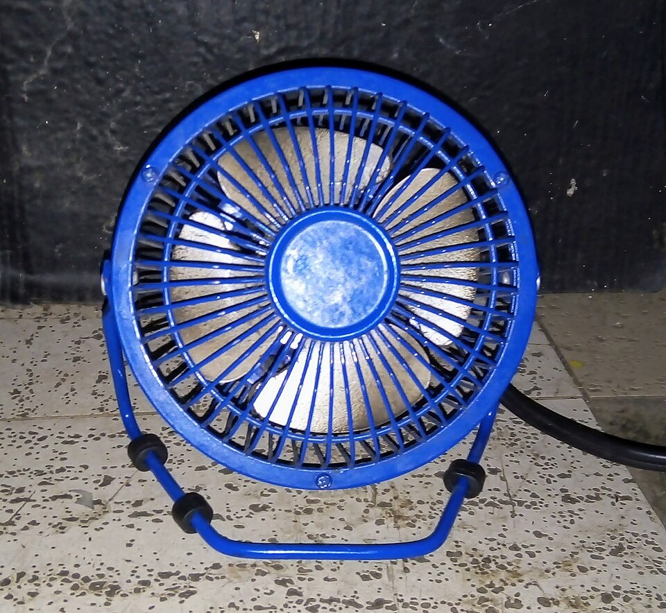 卓上扇風機が電気で羽根を回し、風を生む様子