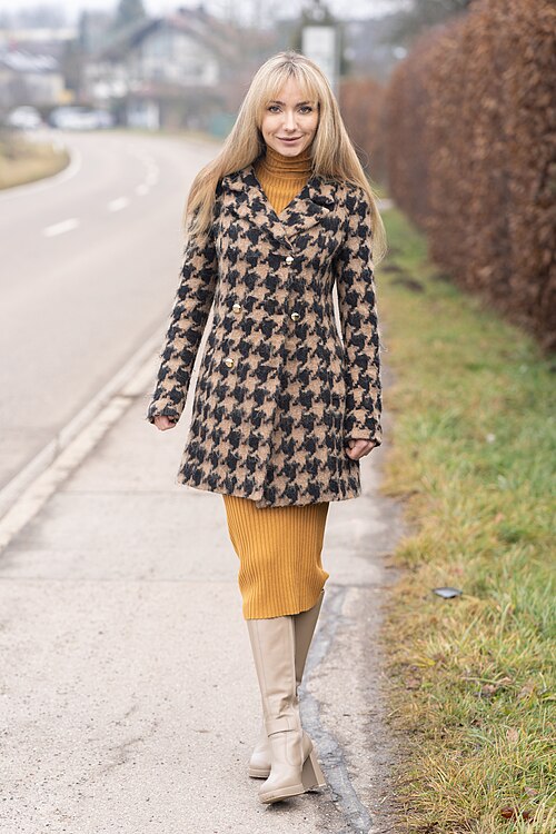 冬のコートとニットの重ね着をした女性（衣類の摩擦が増える状況）