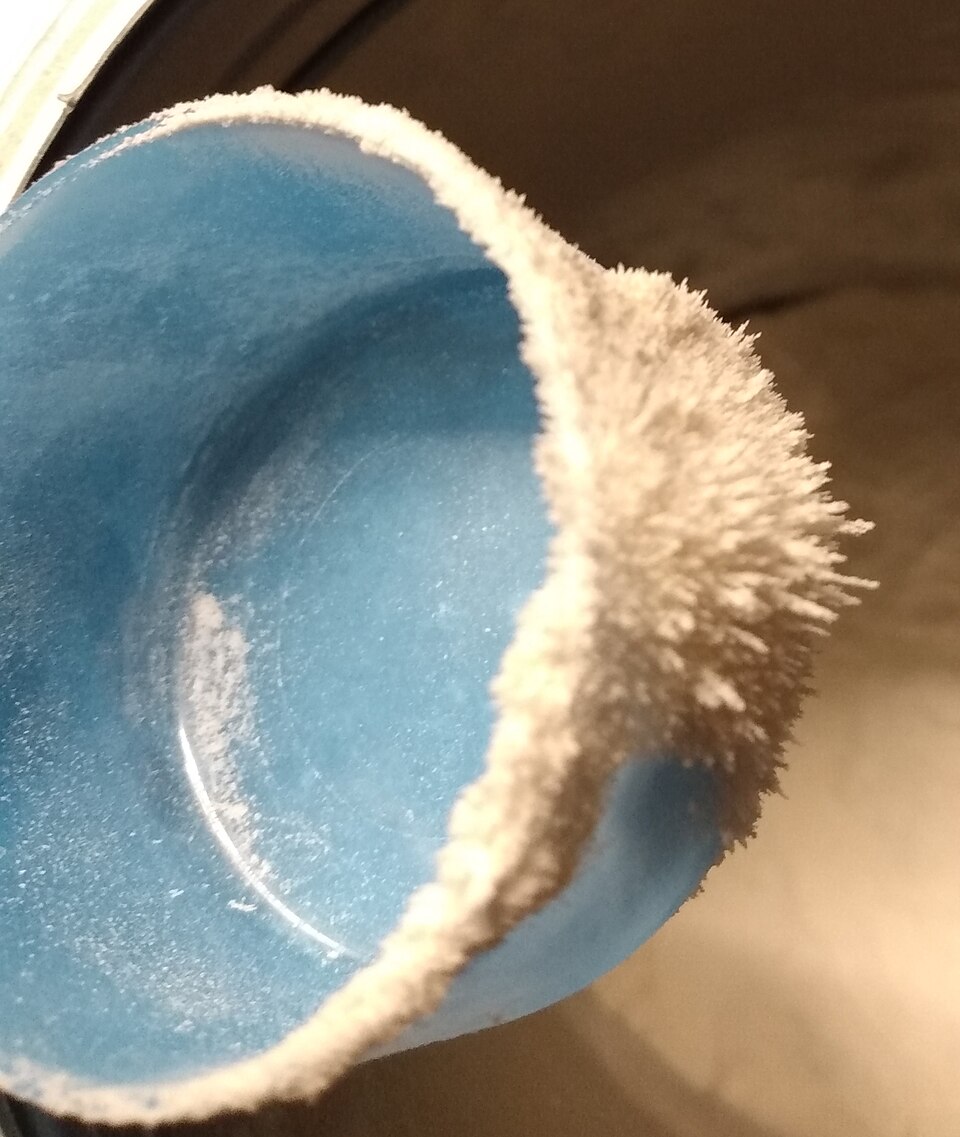 Electric field lines evident in nutritional supplement powder on statically-charged plastic scoop